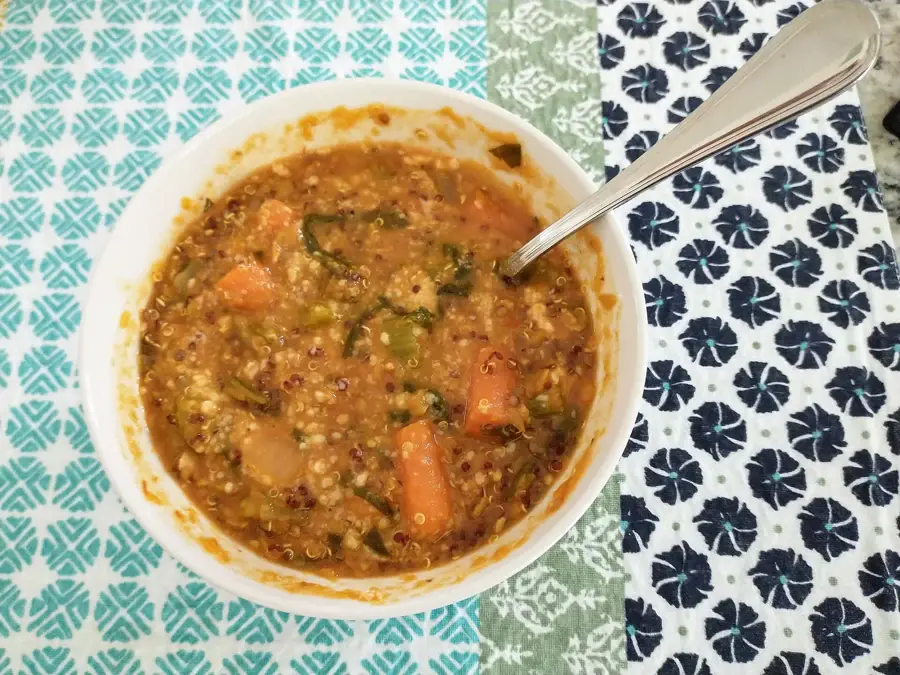 Bol de soupe de lentilles vertes et corail aux carottes, cuillère posée sur le bord